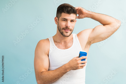 Confident Male With Antiperspirant Against Turquoise Background