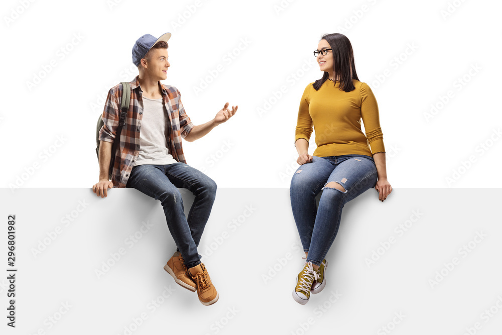 Male student sitting on a panel and talking to a female friend - obrazy, fototapety, plakaty 