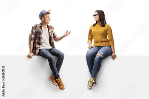 Male student sitting on a panel and talking to a female friend