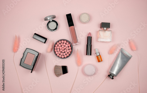 Makeup and cosmetic beauty tools on pink background.