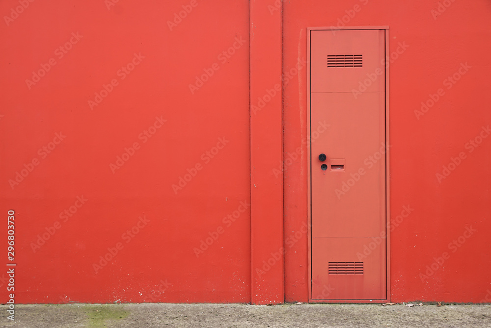 Fototapeta premium Cement concrete wall texture with modern red door.