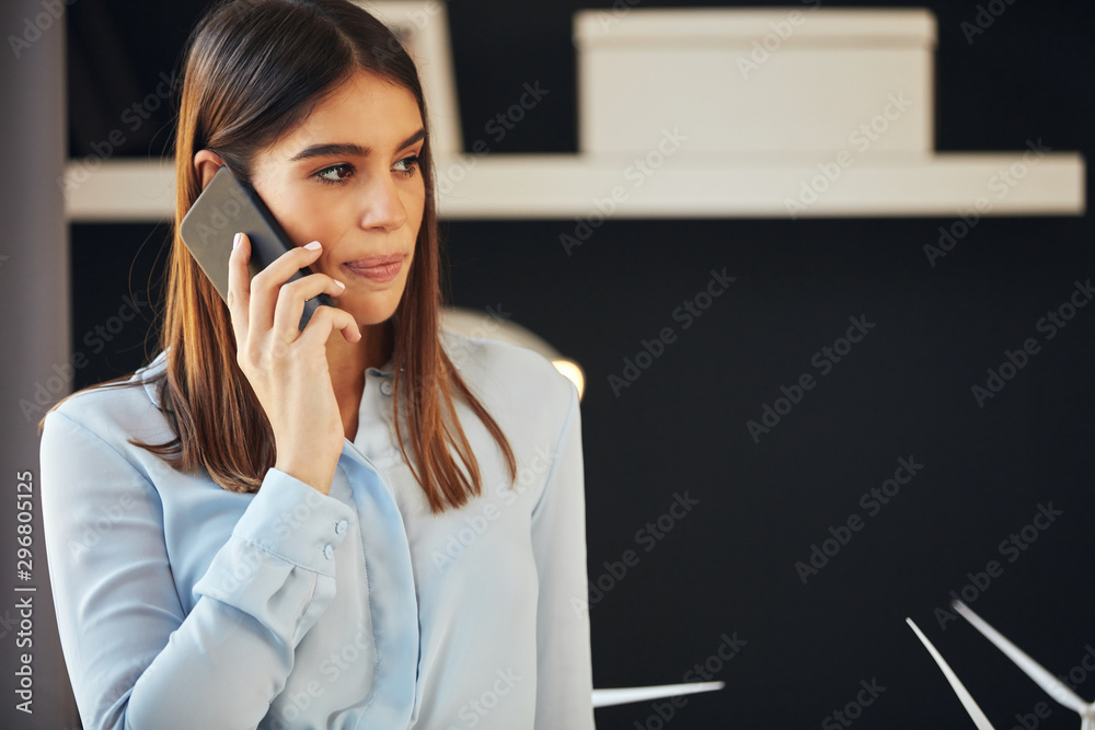 Portrait of beautiful caucasian businesswoman in formal wear standing in office talking on smart phone. Portrait of beautiful caucasian businesswoman in formal wear standing in office talking on smart phone.