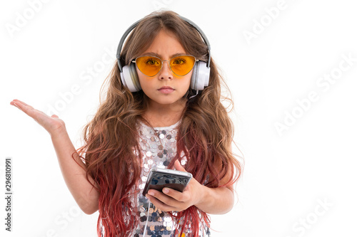 Photography Girl in headphones expresses bewilderment ar white background