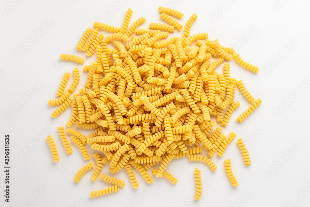 Obraz premium Group of dried fusilli Italian pasta in a round shape ready to be cooked, isolated on white table, with view from above 