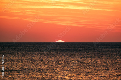 Faszinierende Abendstimmung: Traumhafter gelb-roter Sonnenuntergang Ã¼ber dem Meer mit einer fast untergegangenen, verschwommenen Sonne