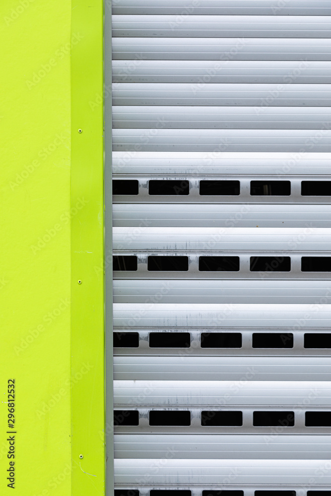 Fragment of roller-shutter door with a part of light green wall Fragment of roller-shutter door with a part of light green wall