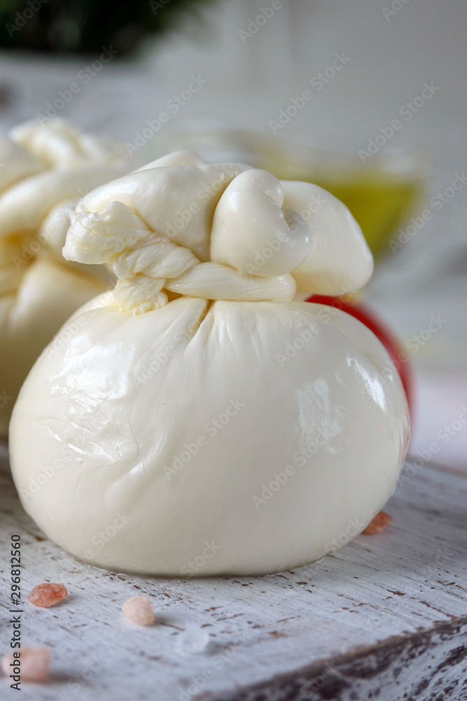 Burrata, Italian fresh cheese made from cream and milk of buffalo or cow. Close-up. Delicate delicacy on a white background. Burrata, Italian fresh cheese made from cream and milk of buffalo or cow. Close-up. Delicate delicacy on a white background.