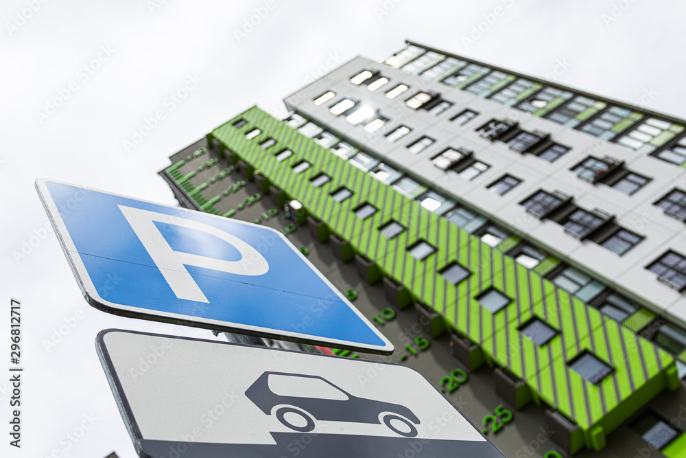 Obraz premium Bottom view of roadsign Way of parking vehicle against new block of flats