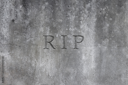Old gray stone headstone with text R.I.P. carved in it