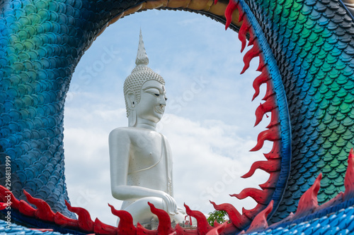 Statue of Large white Buddha In the middle cycle space of Dragon scales, Landmark at Wat Roi Phra Phutthabat Phu Manorom, Mukdahan, Thailand photo