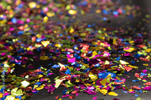 This is a photograph of metallic colorful confetti placed on a Black background