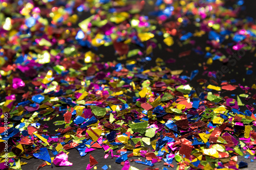 This is a photograph of metallic colorful confetti placed on a Black background