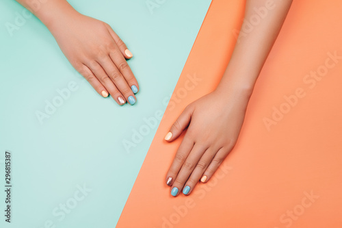 Manicure in trendy colors  coral  metallic yellow and mint on colorful background. Flat lay style.
