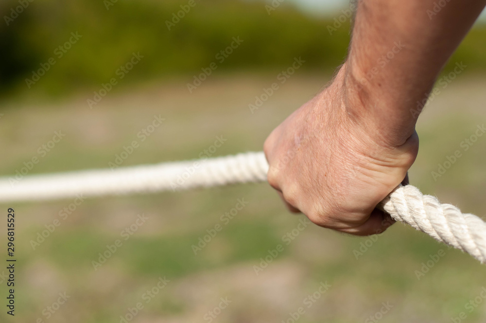 strong male hands hold the rope