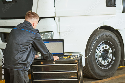 Truck repair service. Mechanic makes computer diagnostic of the semitruck photo