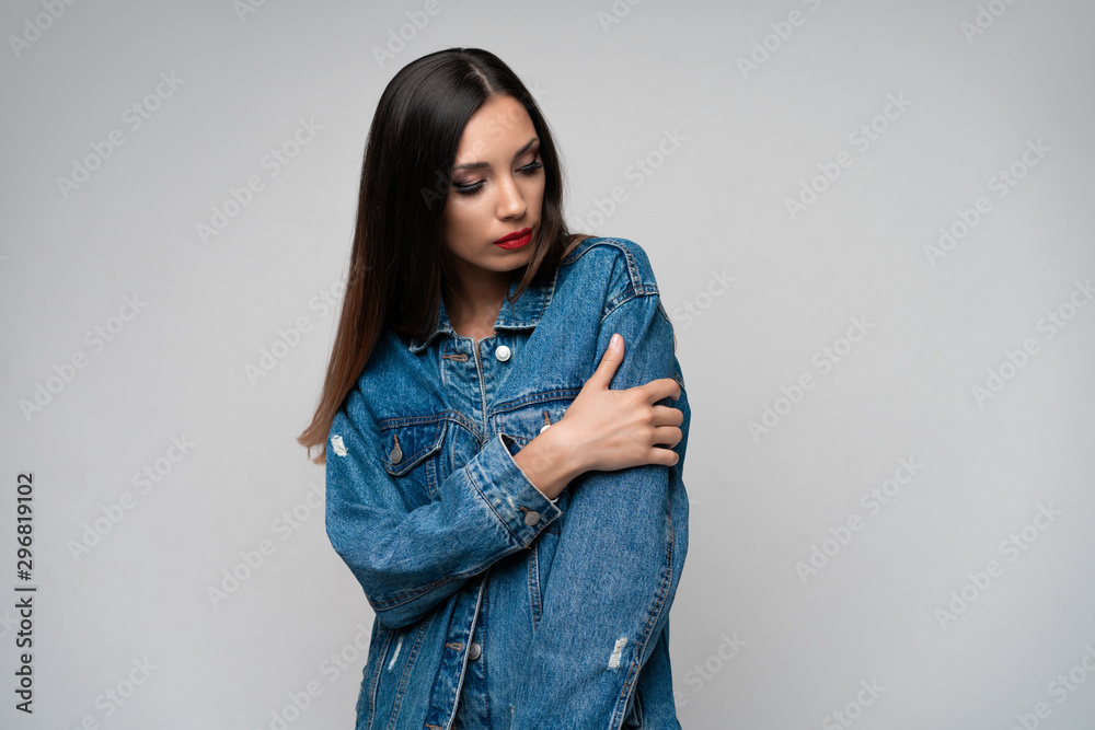 Beautiful caucasian girl in a denim jacket posing in the studio on a white background. Beautiful caucasian girl in a denim jacket posing in the studio on a white background.