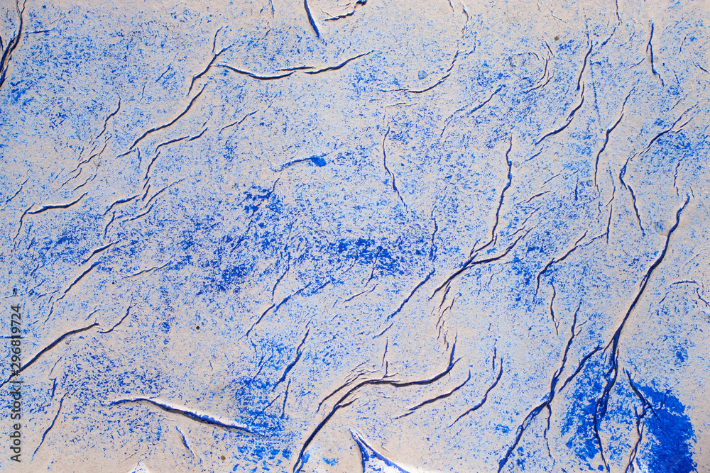 Naklejka premium A sheet of crumpled paper smeared with blue paint. Abstract background for designers.