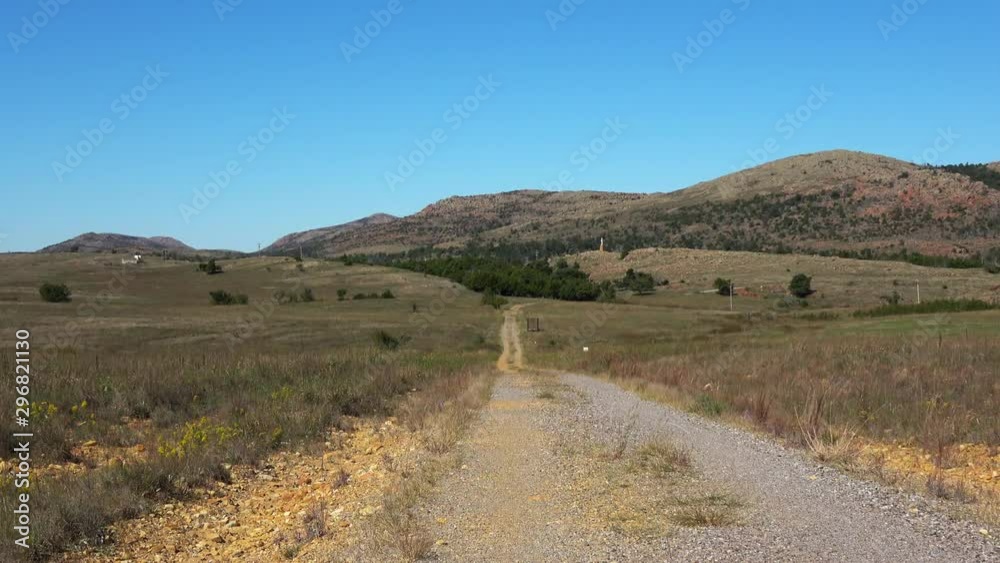 View of beautiful landscape with road going though the prairie in the Wichita Mountains. View of beautiful landscape with road going though the prairie in the Wichita Mountains.
