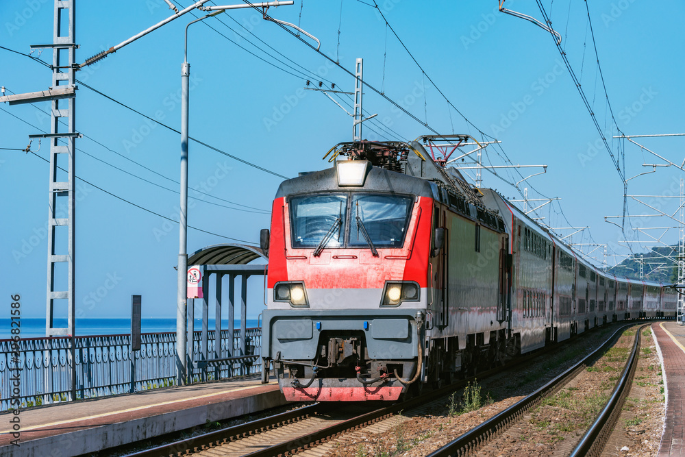 Passenger double deck train moves along the platform by the Black sea coast. Sochi. Russia.