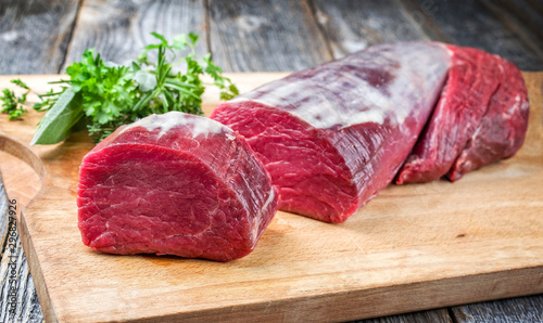 Photographie Dry aged beef fillet steak natural offered as closeup on a wooden cutting board