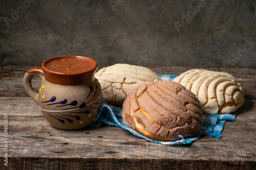 Fototapeta Naklejka Na Ścianę i Meble -  Mexican hot chocolate with sweet conchas bread on wooden background