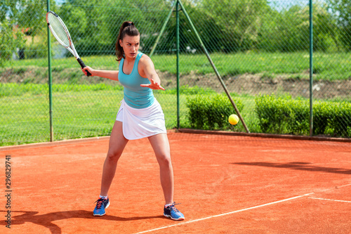 Beautiful girl fully concentrated to hit a tennis ball © didesign