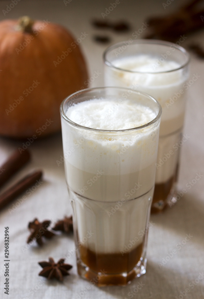 Homemade pumpkin latte in tall glasses and pumpkin on a linen tablecloth. Rustic style. Homemade pumpkin latte in tall glasses and pumpkin on a linen tablecloth. Rustic style.