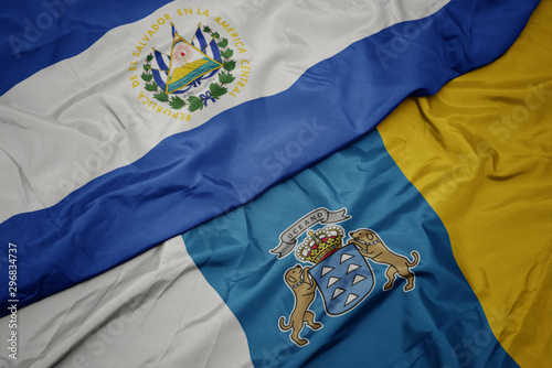 waving colorful flag of canary islands and national flag of el salvador.