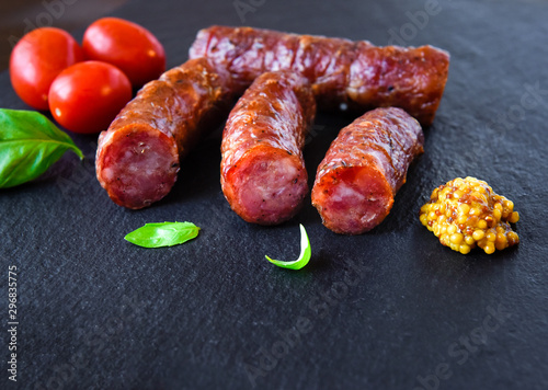 Grilled smoked sausage with herbs and vegetables a dark background
