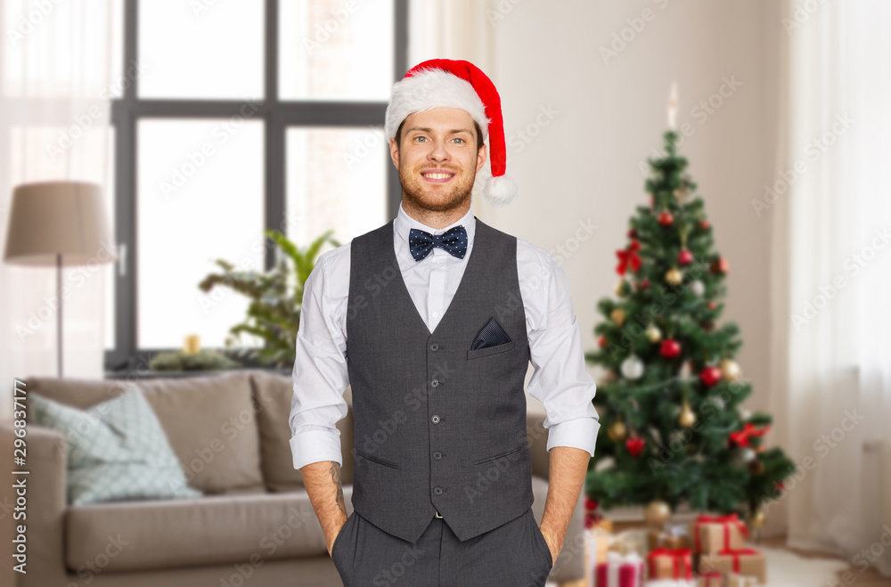 celebration, people and holidays concept - happy man in santa hat and suit over christmas tree on home background celebration, people and holidays concept - happy man in santa hat and suit over christmas tree on home background
