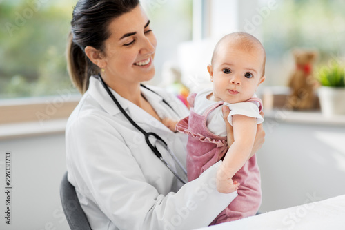 medicine, healthcare and pediatrics concept - smiling female pediatrician doctor or nurse holding baby girl patient at clinic or hospital