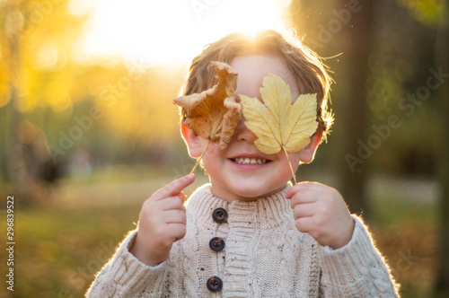 Fototapet Happy little child baby boy laughing and playing in the autumn day