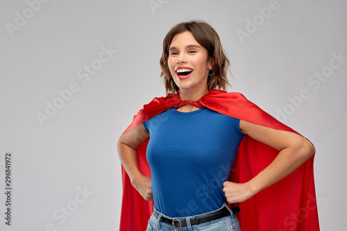 Bild auf Leinwand women's power and people concept - happy woman in red superhero cape over grey b