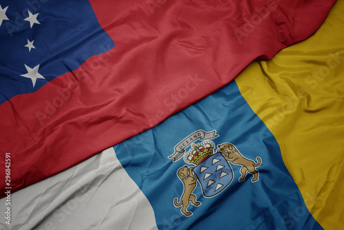 waving colorful flag of canary islands and national flag of Samoa .