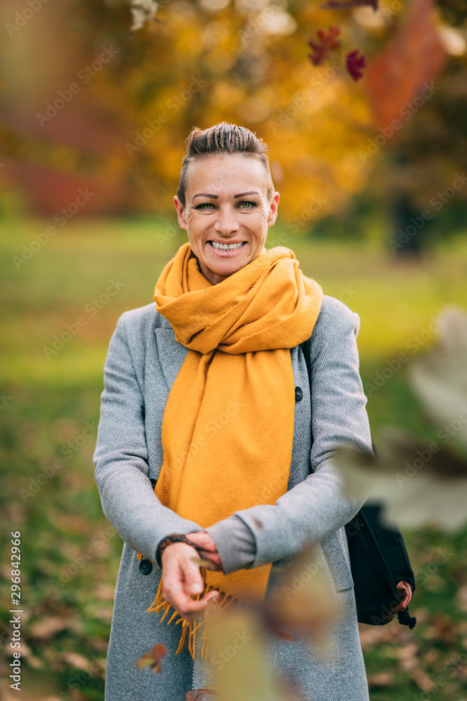 Portrait of happy woman wearing yellow scarf at the park in autumn Portrait of happy woman wearing yellow scarf at the park in autumn