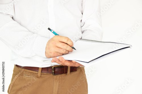 A man holds a large notebook in his hands, and writes something in it. Business concept isolated on white background. photo