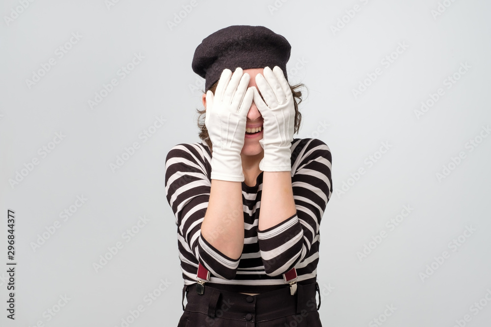 Mime caucasian woman covering her eyes waiting for surprise. Studio shot