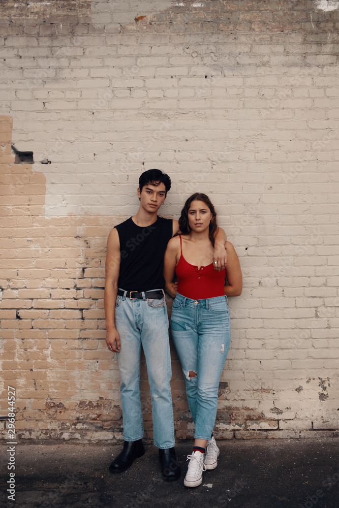 Portrait of friends standing in front of brick wall Portrait of friends standing in front of brick wall