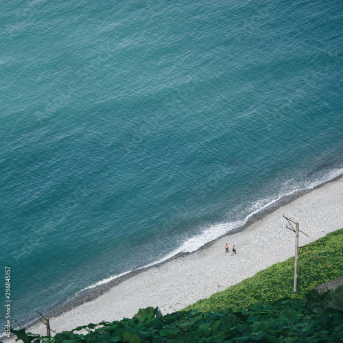 Aerial view of men walking on road along seashore