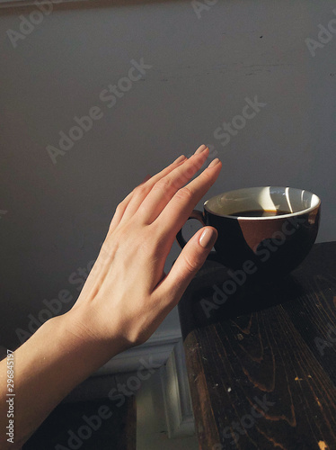 Woman's hand taking coffee cup