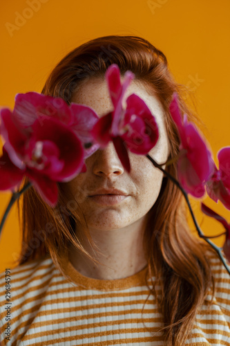 Woman with an orchid covering eyes