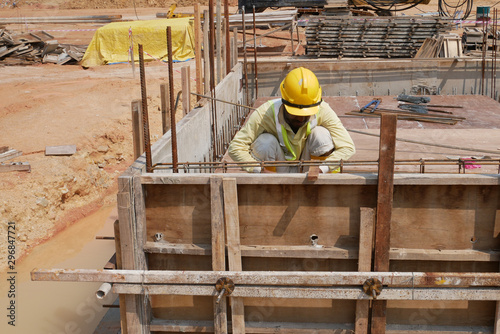 Canvas Print KUALA LUMPUR, MALAYSIA -MARCH, 2019: Construction workers installing & fabricating ground beam timber form works at the construction site