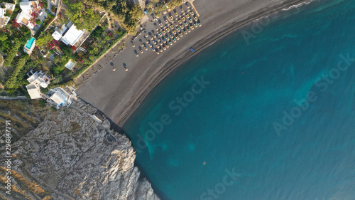 Aerial drone photo of famous seaside village and organised with sun-beds and umbrellas sandy beach of Kamari  Santorini island  Cyclades  Greece