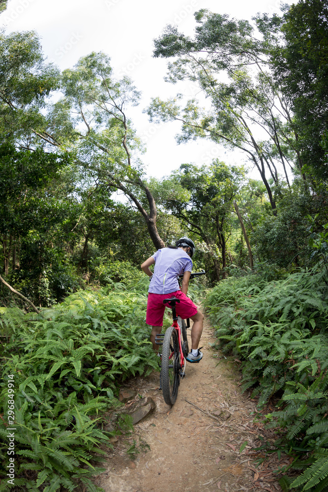 Cross country biking cyclist relax and drinking water on tropical rainforest trail Cross country biking cyclist relax and drinking water on tropical rainforest trail