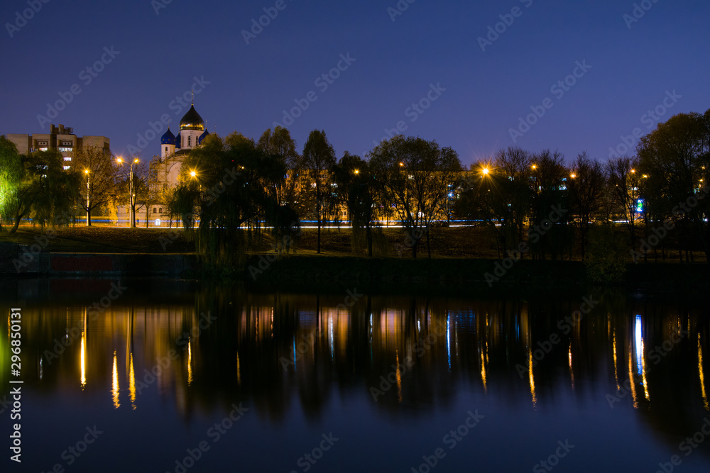 Night lighting of the city, cityscape, Orthodox Church near the pond.