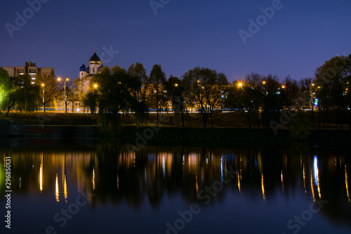 Night lighting of the city, cityscape, Orthodox Church near the pond.