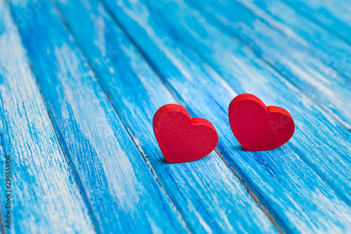 Two red hearts on blue wood background