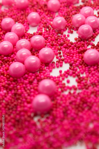 This is a photograph of Pink round sprinkles isolated on a White background