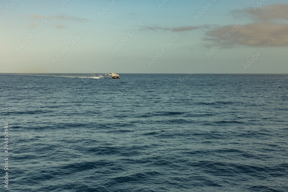 Las Americas, Tenerife, Spain - May 25, 2019: View to the small high-speed ferry from another ferry departing for the island of La Gomera early morning from the port of Los Cristianos