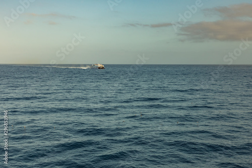 Las Americas, Tenerife, Spain - May 25, 2019: View to the small high-speed ferry from another ferry departing for the island of La Gomera early morning from the port of Los Cristianos © Yury